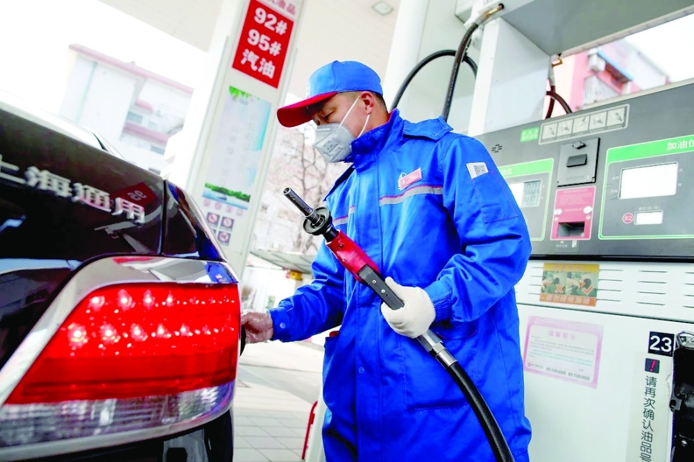 A car attendant refuels a car at a gas station in Beijing. — Reuters