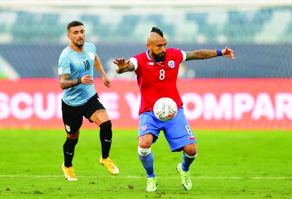 Chile's Arturo Vidal in action with Uruguay's Giorgian de Arrascaeta. -- Reuters