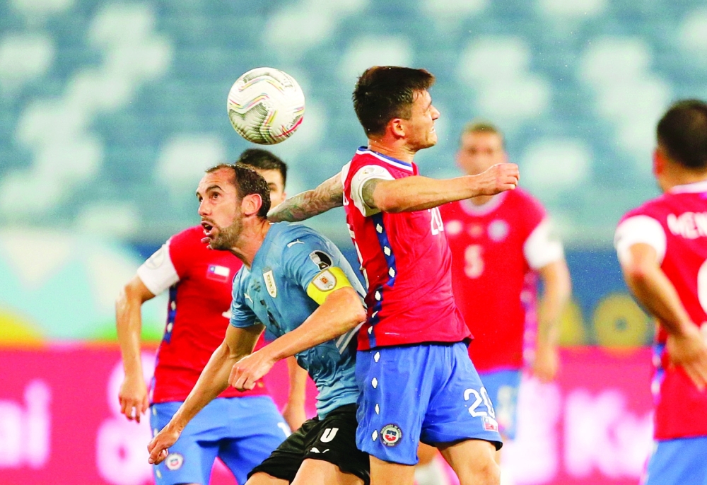 Uruguay's Diego Godin in action with Chile's Charles Aranguiz. -- Reuters