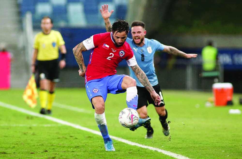 Chile's Eugenio Mena (L) and Uruguay's Nahitan Nandez vie for the ball. -- AFP