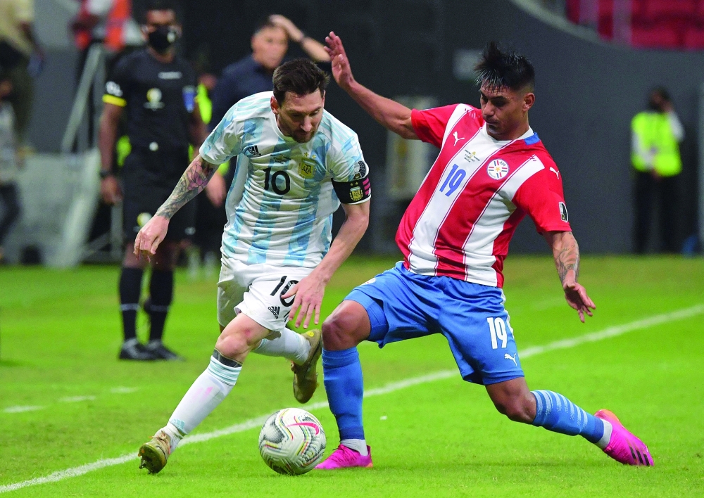 Argentina's Lionel Messi (L) and Paraguay's Santiago Arzamendia vie for the ball. -- AFP 