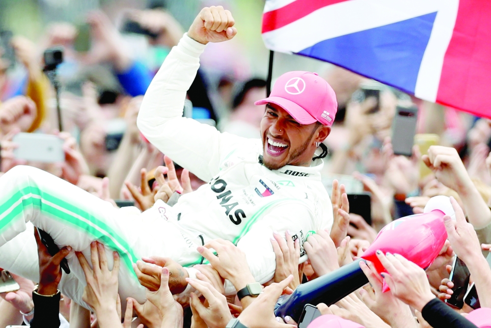 Mercedes' Lewis Hamilton celebrates with the crowd after winning the 2020 British Grand Prix at Silverstone Circuit. -- Reuters