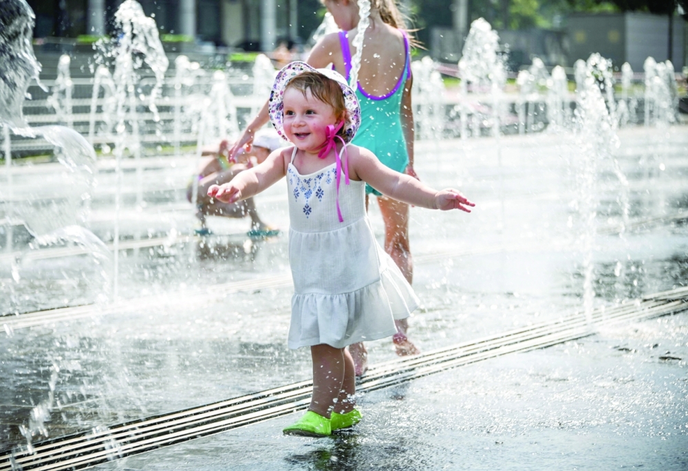 People cool off in a fountain during a hot summer day in Moscow on Thursday. Moscow has been hit by a historic heat wave this week, with temperatures reaching a 120-year record due to the effects of climate change. - AFP 