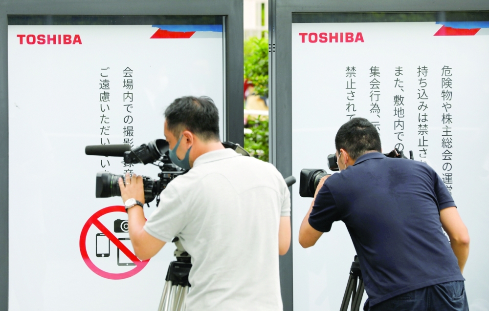 TV cameramen film outside  a venue of Toshiba Corp's annual general meeting with its shareholder in Tokyo. - Reuters