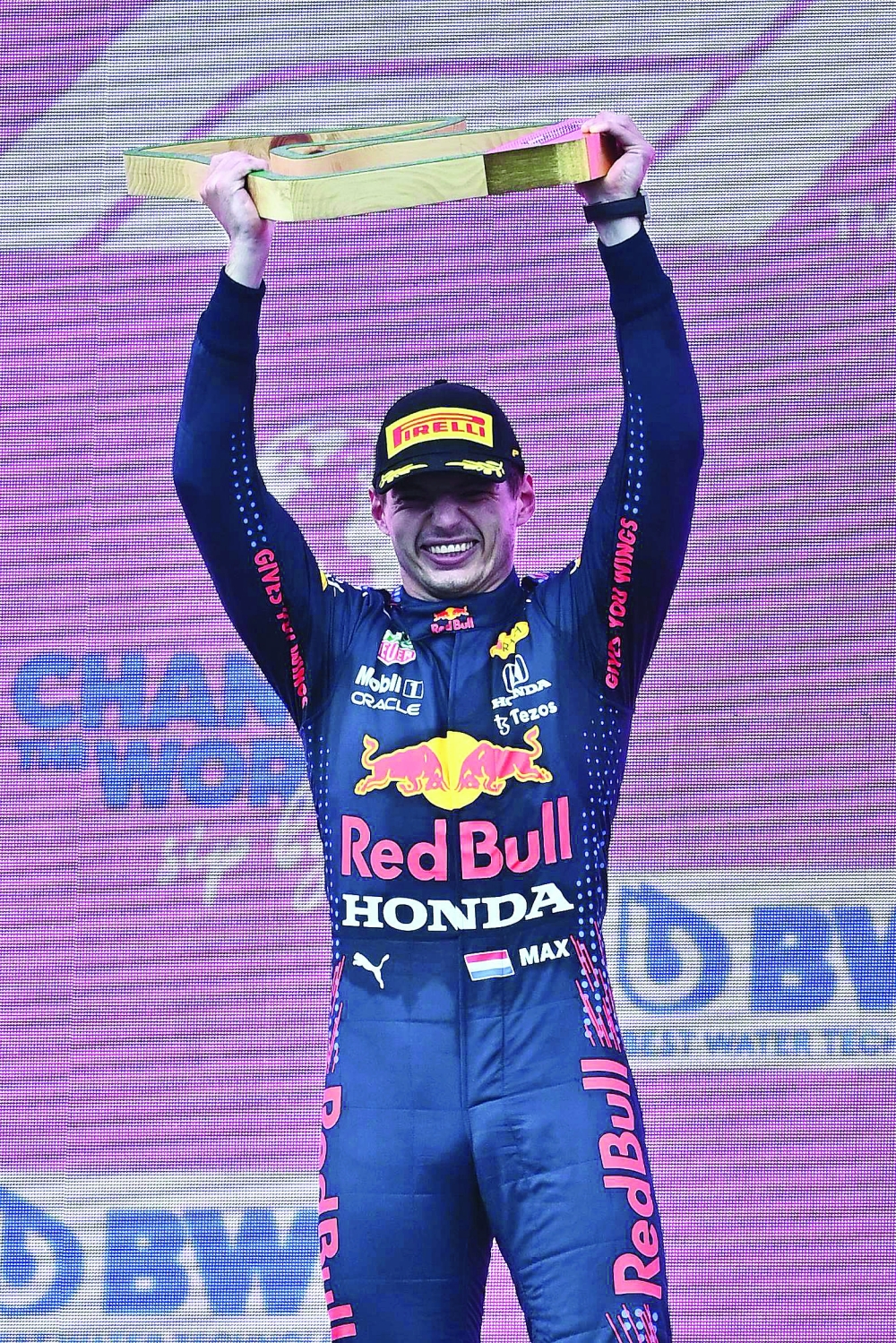 Winner Red Bull's Dutch driver Max Verstappen celebrates his victory with the trophy on the podium after the Formula One Styrian Grand Prix at the Red Bull Ring race track in Spielberg, Austria, on June 27, 2021. / AFP / Joe Klamar

