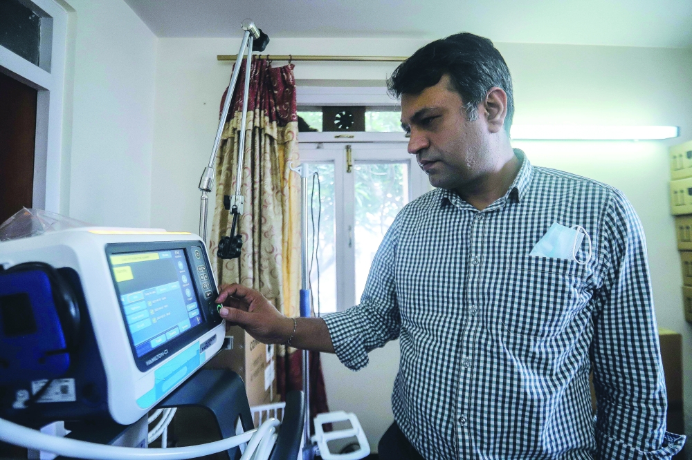 Co-founder of the non-profit organisation Nepal Ventilator Services, Bishal Dhakal, checks ventilators at a warehouse before they are rented out to hospitals in Kathmandu.  - AFP
