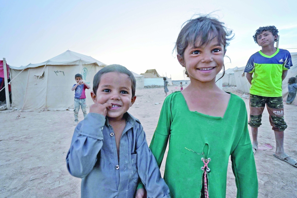 Children look on as they stand near tents at the Suweida camp for people internally displaced by conflict, near Yemen's northern city of Marib. - AFP File Photo
