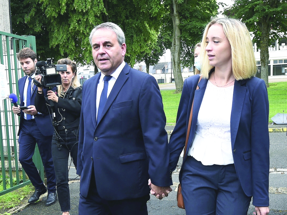 Xavier Bertrand and his wife Vanessa arrive to vote at a polling station in Saint-Quentin, for the second round of the French regional elections on Sunday. — AFP