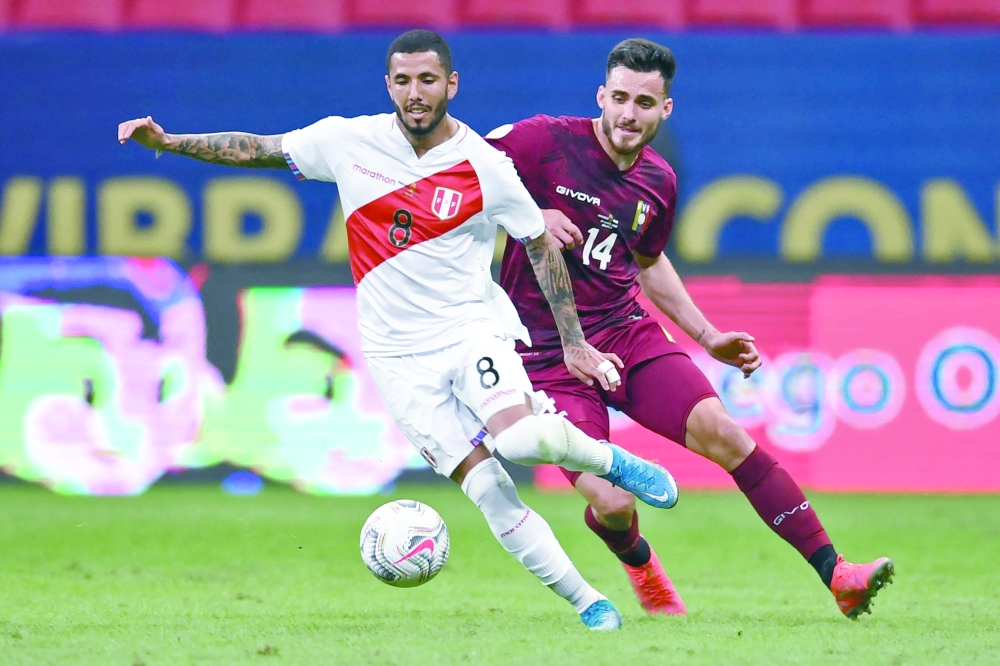 Peru's Sergio Pena (L) and Venezuela's Luis Del Pino Mago vie for the ball. -- AFP