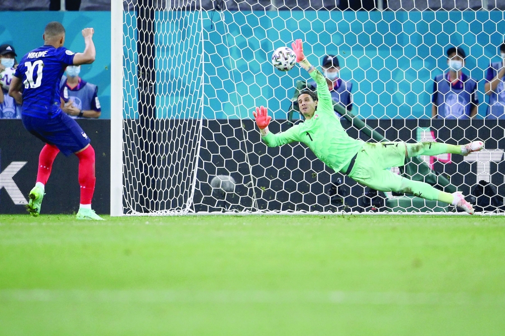 Switzerland's goalkeeper Yann Sommer (R) saves a penalty by France's forward Kylian Mbappe. -- AFP