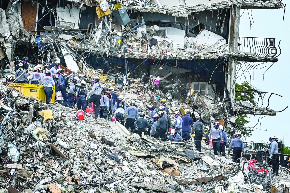 Search and rescue teams look for possible survivors in the partially collapsed 12-story Champlain Towers South condo building on Tuesday in Surfside, Florida. -- AFP