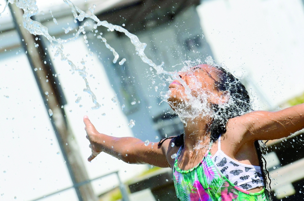 Kids cool off at a community water park on a scorching hot day in Richmond, British Columbia. -- AFP