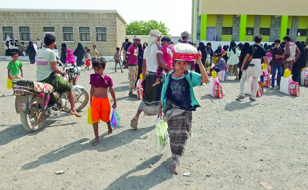People displaced by conflict receive food aid in the Tuhayta district of  Hodeida on Wednesday. -- AFP

