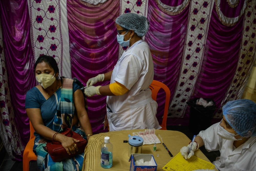 A health worker inoculates a woman with the Covishield, AstraZeneca-Oxford's Covid-19 coronavirus vaccine at a temporary camp held in Siliguri on July 2, 2021.  
