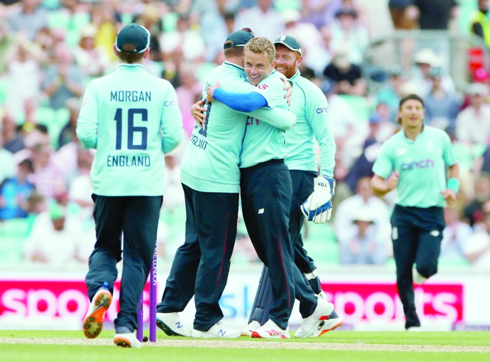 England's Sam Curran celebrates with team-mates after taking the wicket of Sri Lanka's Chamika Karunaratne. -- Reuters