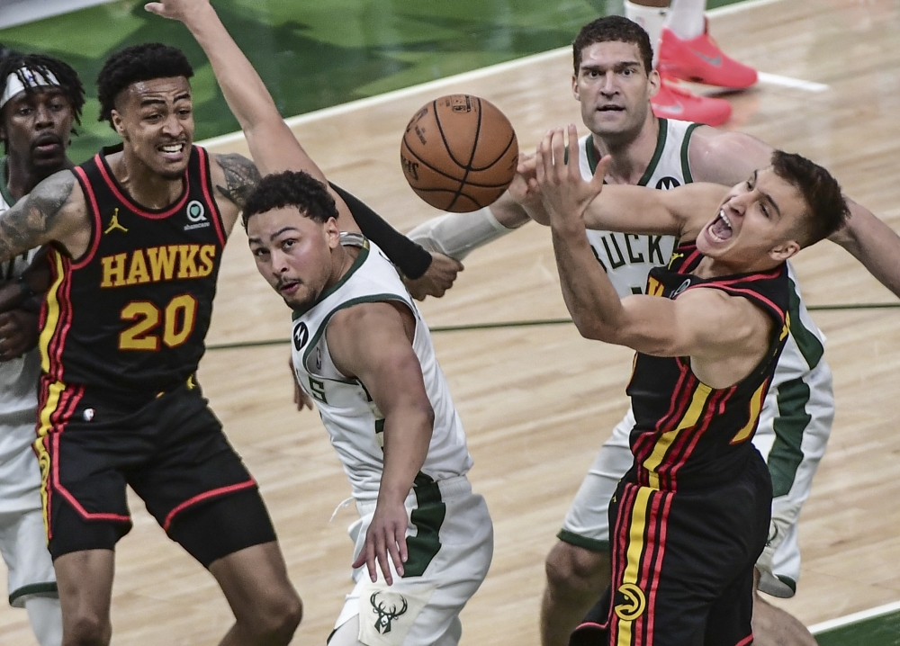 Atlanta Hawks guard Bogdan Bogdanovic (13) reaches for a rebound against Milwaukee Bucks guard Bryn Forbes (7) and Brook Lopez (11) in the fourth quarter. -- USA Today Sports