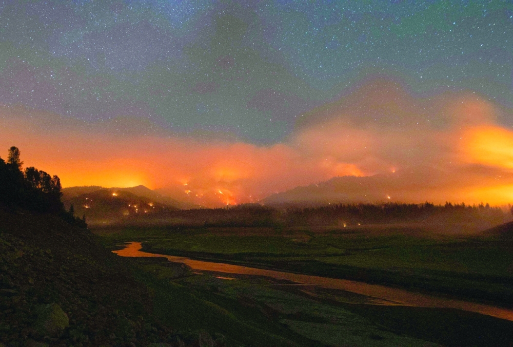 Flames surround a drought-stricken Shasta Lake during the 'Salt fire' in Lakehead, California, as firefighters battle nearly a dozen wildfires in the region following a heatwave and multiple lightning strikes. - AFP 
