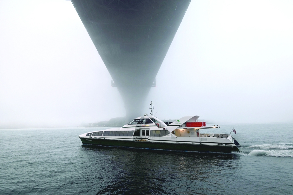 A ferry makes its way into Sydney Harbour as heavy fog floats over the Harbour Bridge. - AFP 