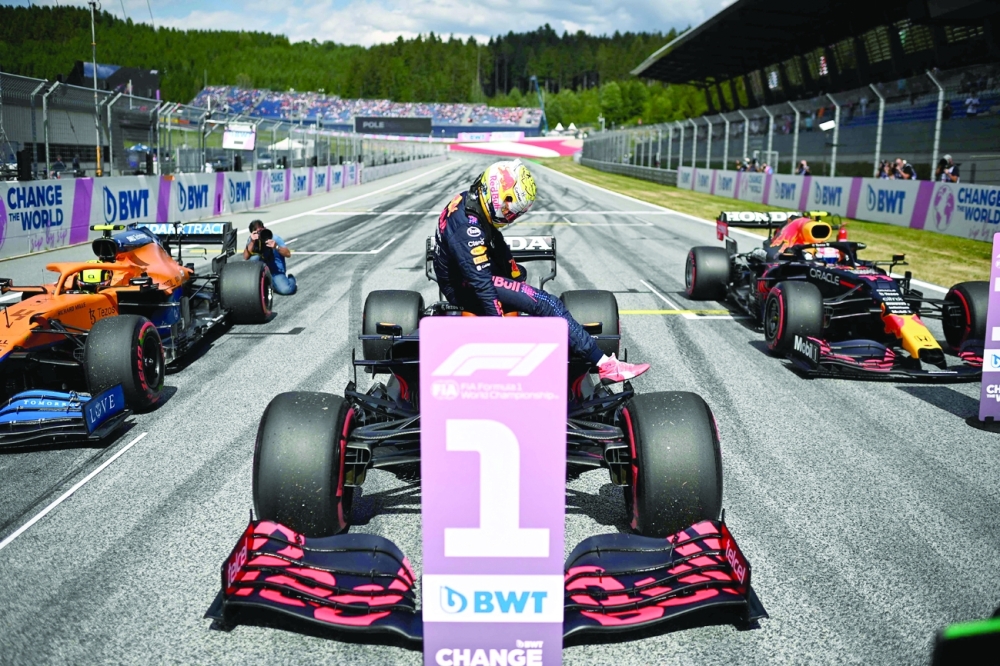 Red Bull's driver Max Verstappen (centre) gets out of his car after winning the pole position ahead of second placed  McLaren's British driver Lando Norris (L) and third placed Red Bull's Mexican driver Sergio Perez. -- AFP