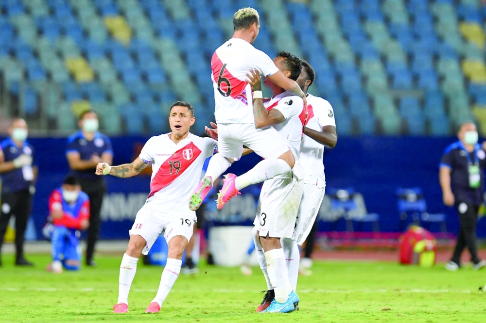 Peru's Miguel Trauco celebrates with teammates after scoring the defining goal during the penalty shootout. -- AFP