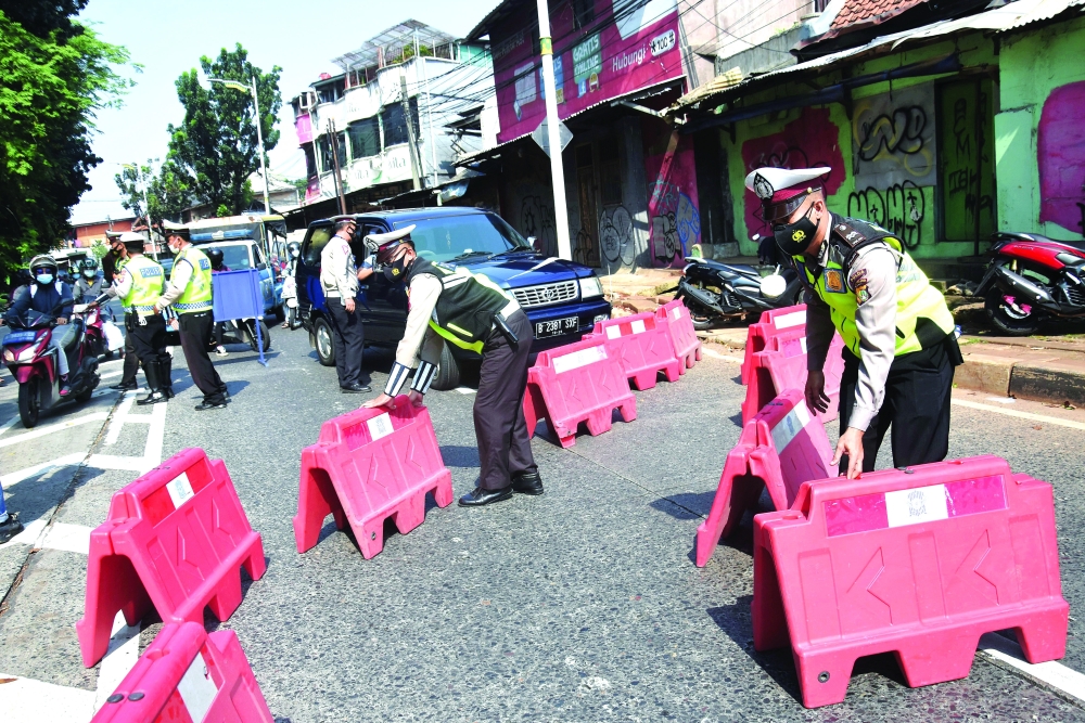 Police officers hold barriers during the imposition of large-scale social restrictions by the government to prevent the spread of the coronavirus disease in Jakarta. - Reuters 
