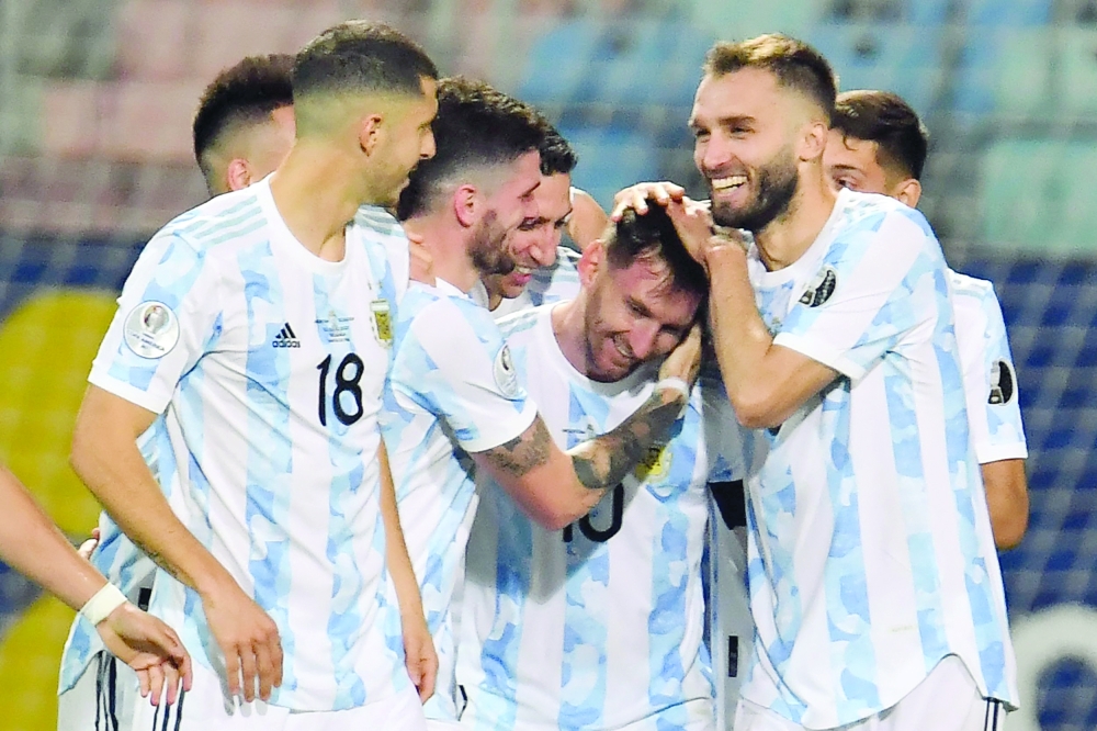 Argentina's Lionel Messi (C) celebrates with teammates after scoring against Ecuador. -- AFP