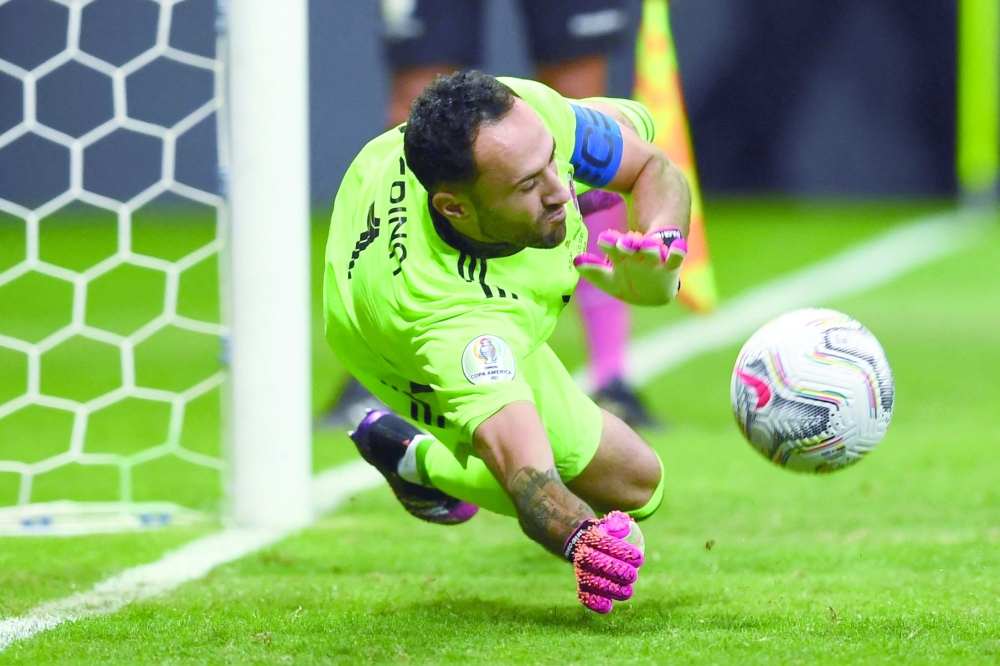 Colombia's goalkeeper David Ospina dives to stop the penalty shot by Uruguay's Jose Maria Gimenez. -- AFP