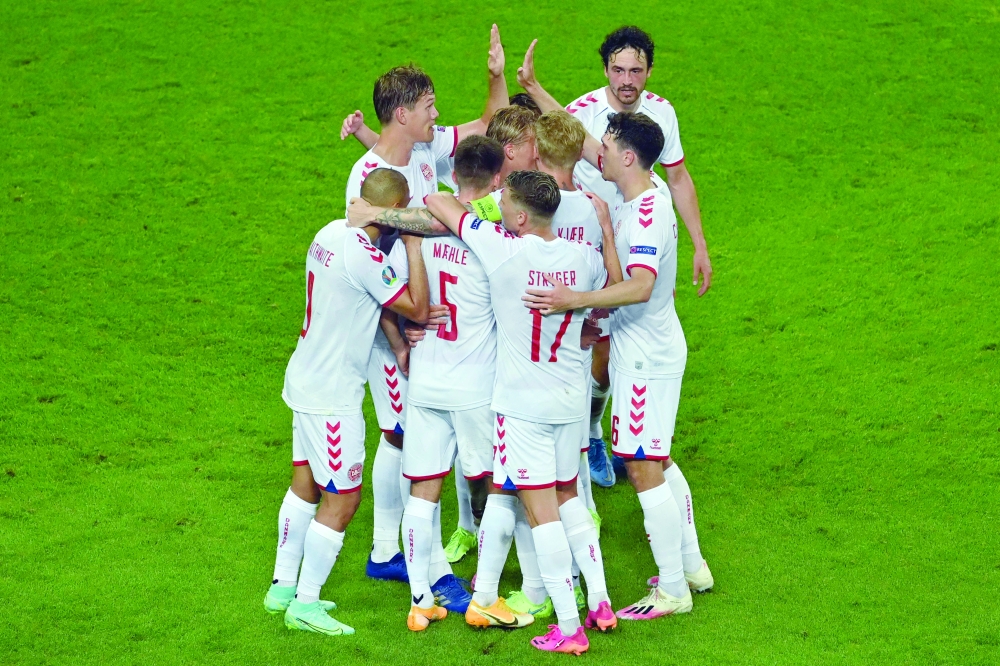 Denmark players celebrate their second goal scored by Kasper Dolberg. -- AFP 