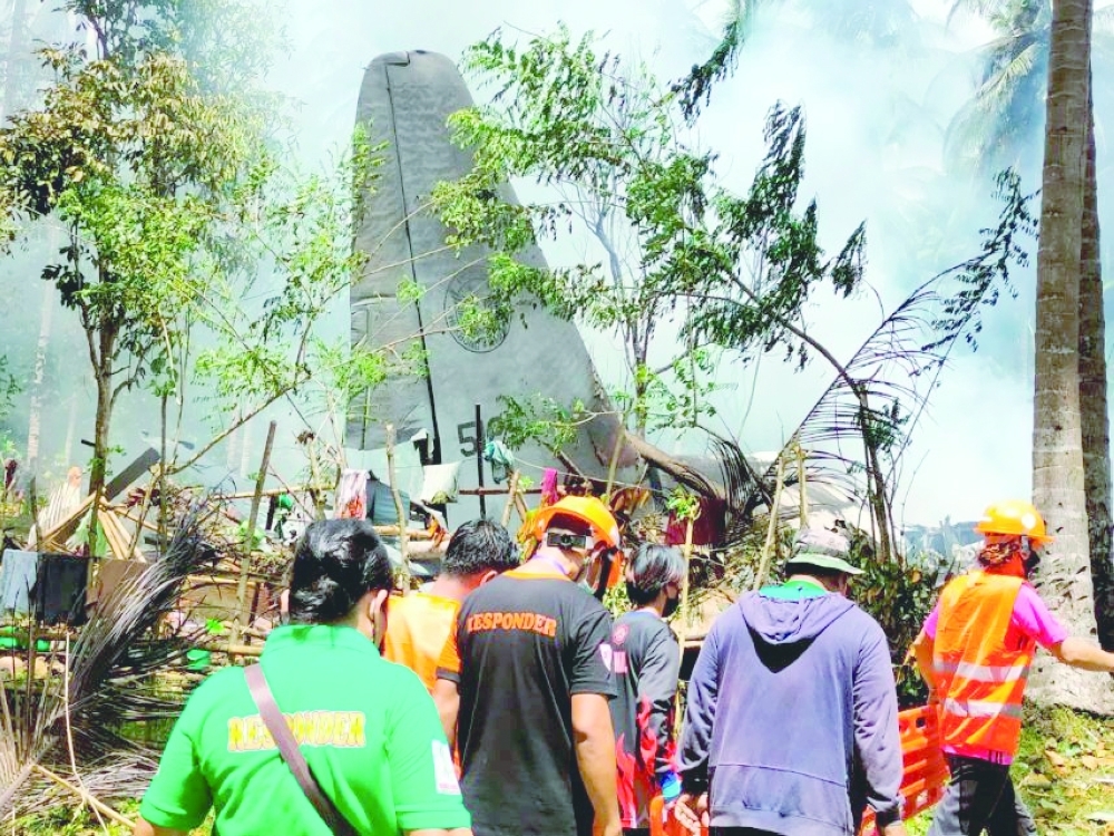 First responders work at the site after a Philippines Air Force Lockheed C-130 plane carrying troops crashed on landing in Patikul, Sulu province. - Reuters
