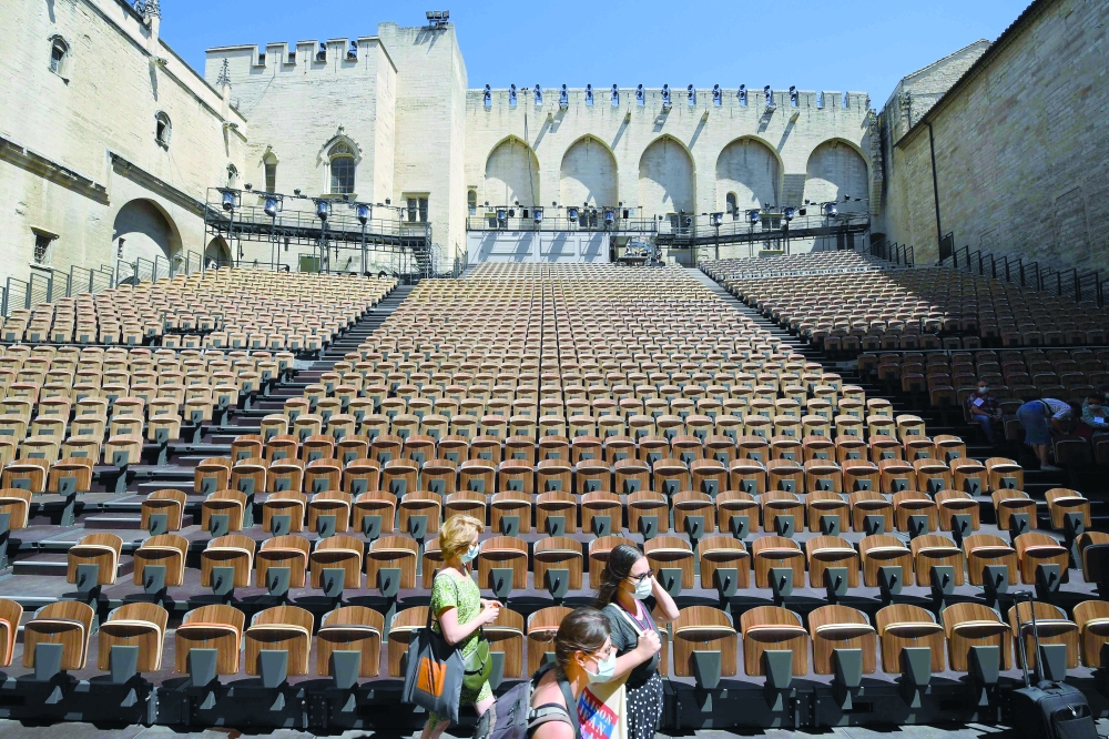 People stand in the "Cour d'honneur" of the Popes' Palace (Palais des papes) stage on the first day of this year edition of the Avignon theatre festival in Avignon on Monday. -- AFP