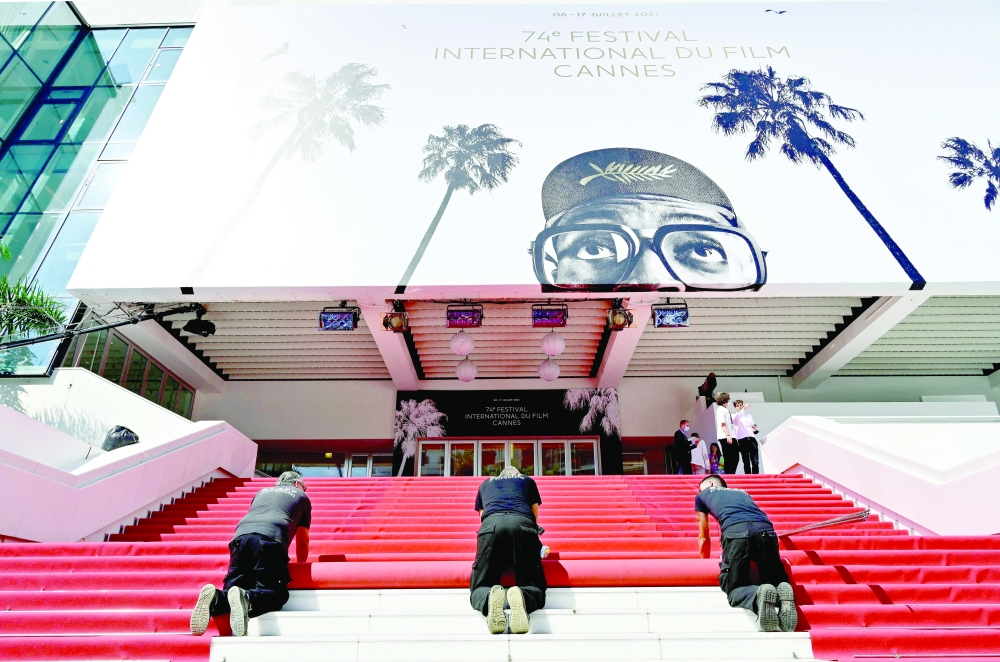 Staff roll the red carpet as the 74th edition of the Cannes Film Festival kicks off in Cannes on Tuesday. -- AFP
