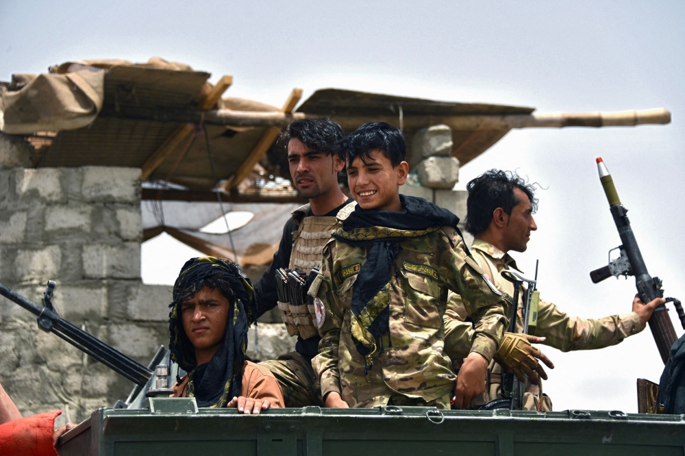 Afghan policemen sit on an armoured vehicle at a checkpoint in Panjwai district of Kandahar province after the Taliban captured a key district in their former bastion recently. - AFP 