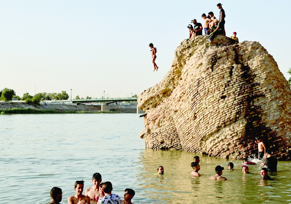 A child jumps into the Tigris river to cool down in the summer heat, in Baghdad. - Reuters