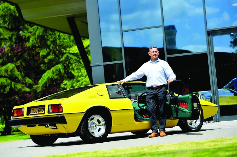 Matt Windle, Managing Director of Lotus, stands with a yellow Lotus Esprit car during an interview at the car plant headquarters in Hethel. - Reuters