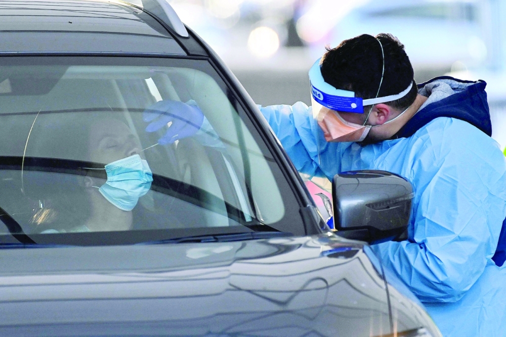 A health worker dressed in protective gear conducts COVID-19 testing at the St. Vincents Hospital drive-through testing clinic at Bondi in Sydney. -- AFP 
