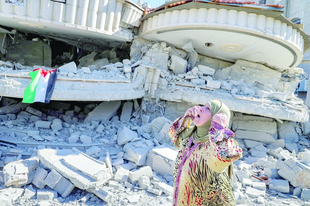 A woman reacts outside a building that belonged to Montasser Shalabi, who was arrested in May on suspicion of carrying out a drive-by shooting attack on an Israeli student, after it was demolished by Israeli forces in the village of Turmus'ayya near Ramallah in the occupied West Bank on Thursday.  -- AFP