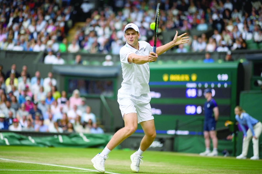 Poland's Hubert Hurkacz in action against Switzerland's Roger Federer.