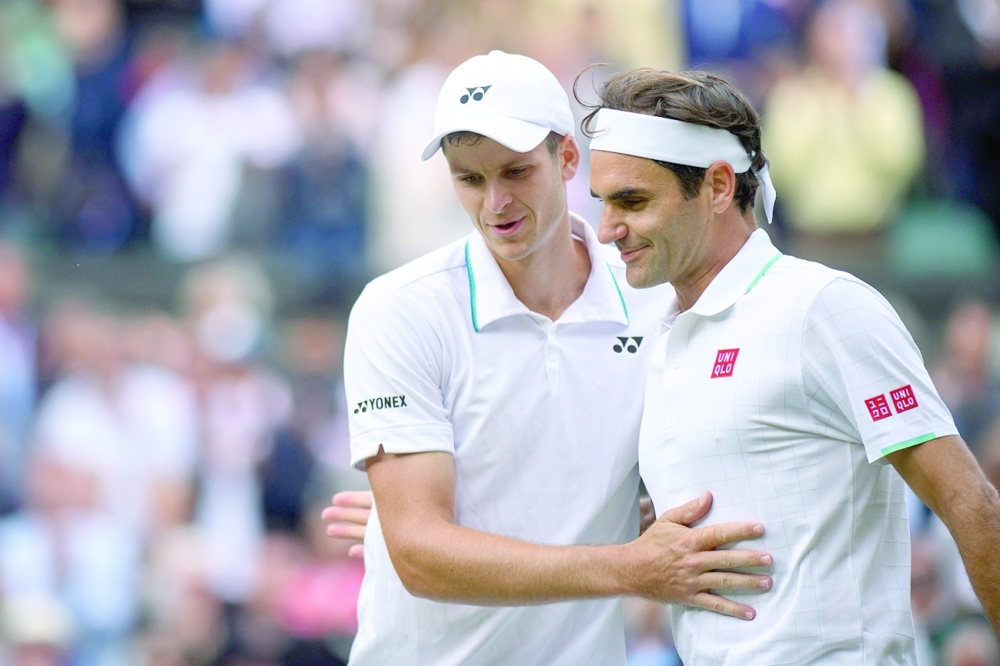Poland's Hubert Hurkacz greets Switzerland's Roger Federer after winning the match.