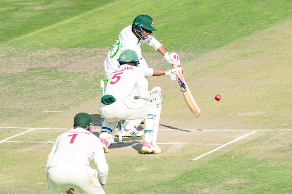 Bangladesh's Mahmudullah (R) plays a shot past Zimbabwe's wicketkeeper Regis Chakabva (C). -- AFP
