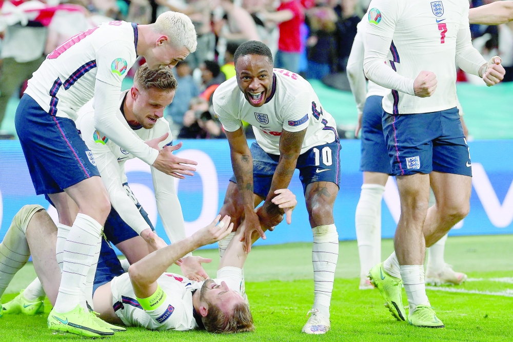 England's players celebrate the second goal against Denmark. -- AFP