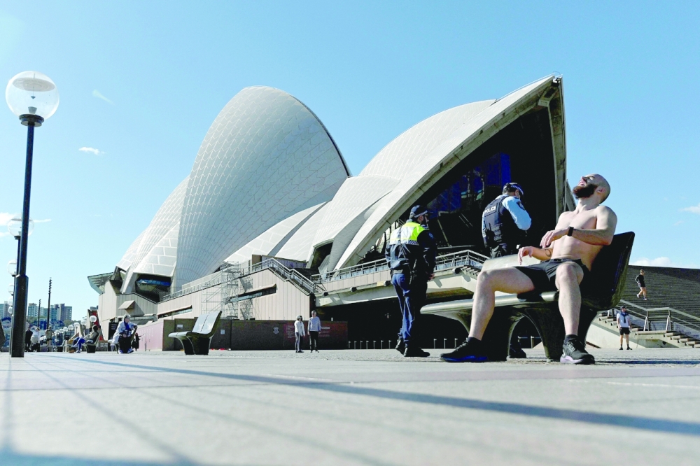 Police officers patrolling in front of the Opera House, usually packed with visitors, as a lockdown in Sydney was tightened due to new Covid infections hit a record and authorities warned an outbreak of the Delta variant was spinning out of control. - AFP 