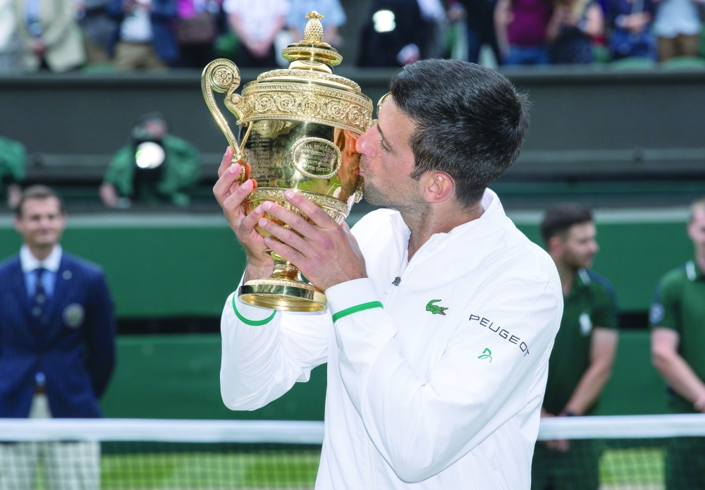 Serbia's Novak Djokovic kisses the trophy as he celebrates after winning his final match against Italy's Matteo Berrettini. -- Reuters
