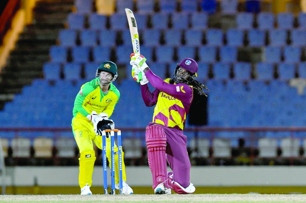 Chris Gayle (R) of West Indies hits 6 as Matthew Wade (L) of Australia watches during the 3rd T20I. between Australia and West Indies at Darren Sammy Cricket Ground, Gros Islet, Saint Lucia, on July 12, 2021. -- AFP 
