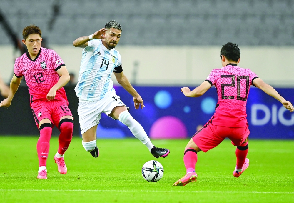 Argentina's Francisco Ortega (C) competes for the ball with South Korea's Um Won-sang (R) and Lee Dong-gyeong (L). -- AFP