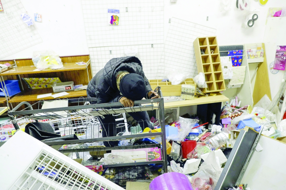 A shop owner weeps inside her looted store at the Diepkloof Square area in Soweto, Johannesburg on Tuesday. -- AFP 