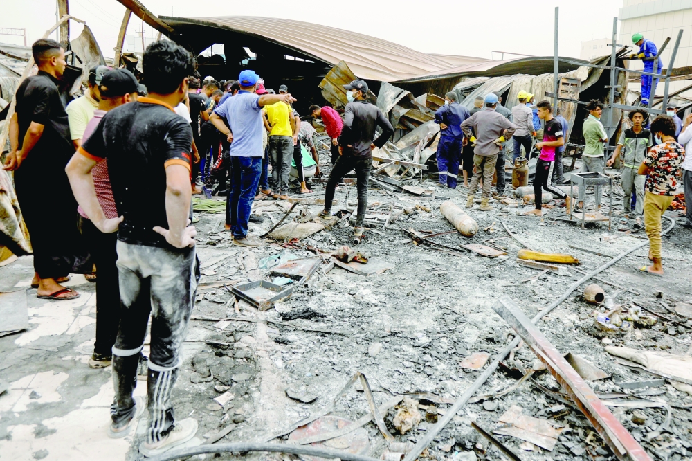 People gather as they inspect the damage at Al Hussain coronavirus hospital. - Reuters