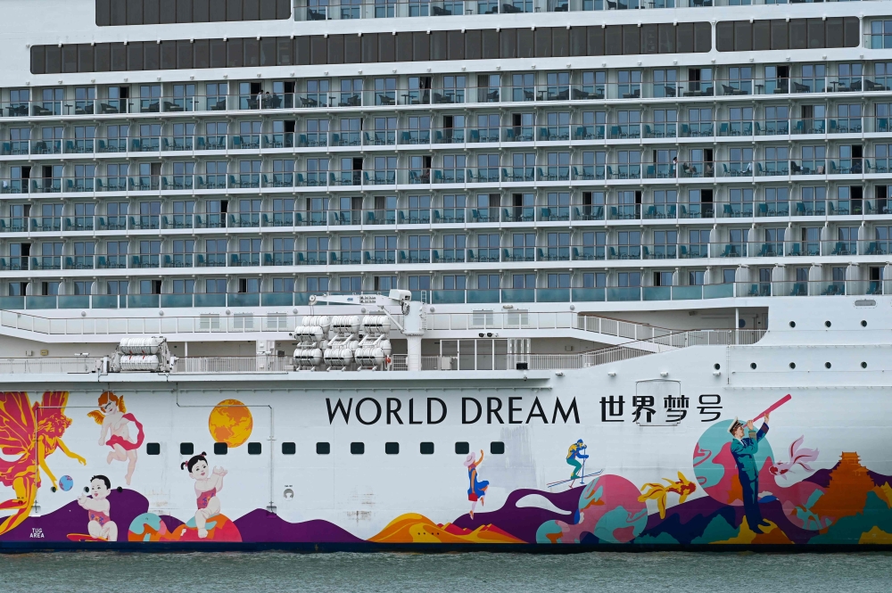 People onboard the Dream Cruises' World Dream cruise ship docked at the Marina Bay Cruise Centre in Singapore on July 14, 2021, after it returned to the city-state following a passenger's positive test for the Covid-19 coronavirus. 
