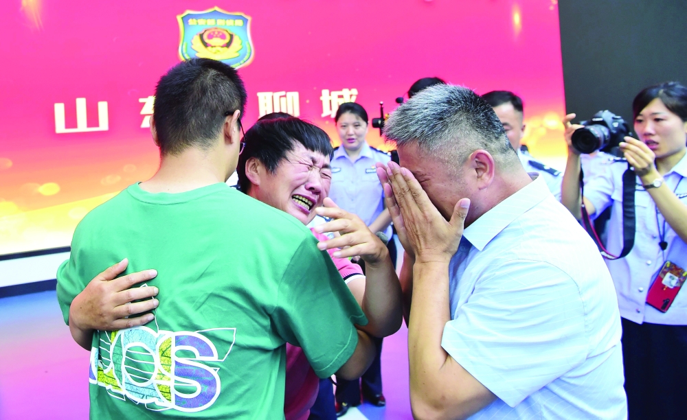 Guo Gangtang, 51, and his wife reunite with their son Guo Xinzhen. - Reuters 