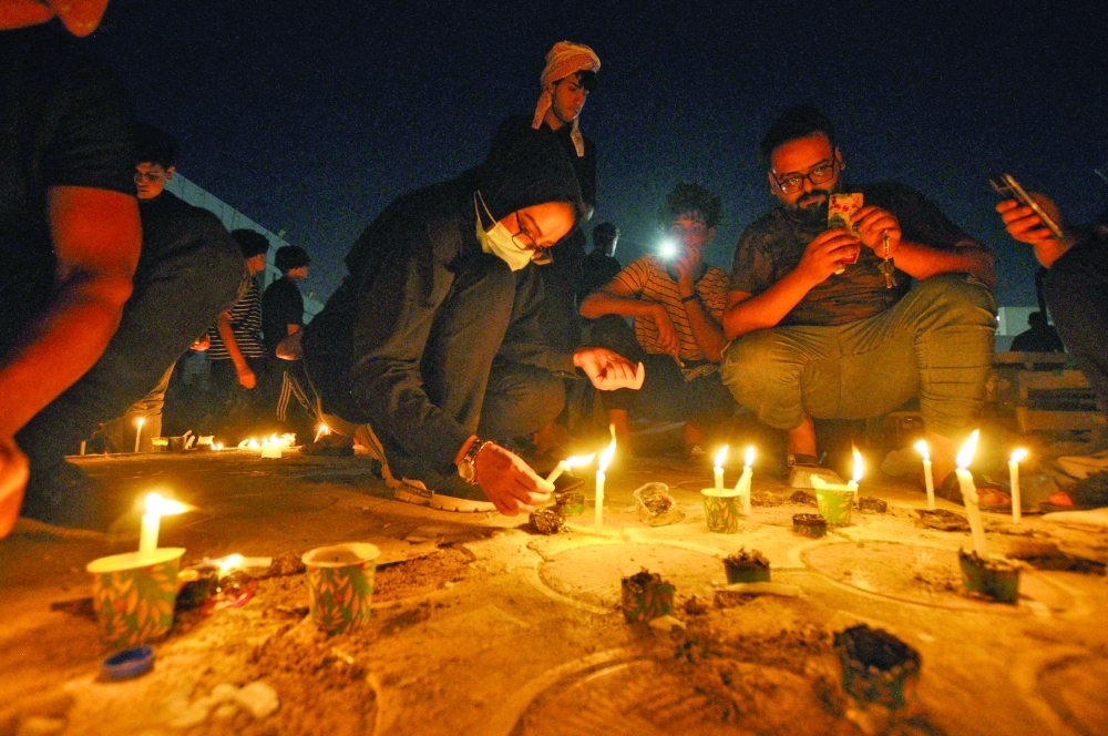 People light up candles for a vigil in mourning for the victims of a fire that swept through a Covid-19 isolation unit at Al Hussein Hospital in Iraq's southern city of Nasiriyah on Tuesday. - AFP  