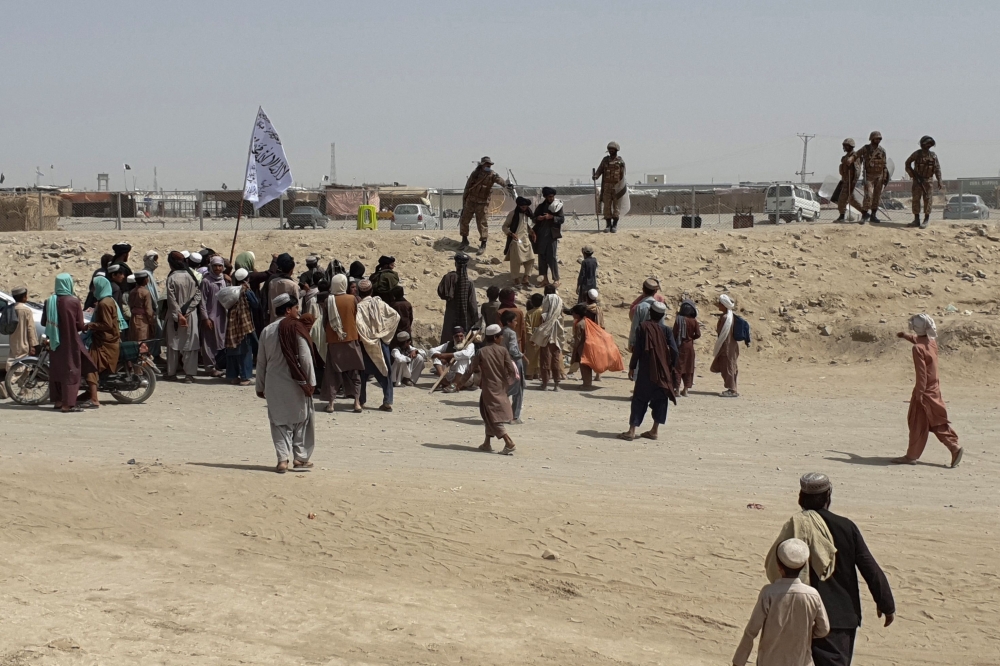 Pakistani border guards disperse stranded people gathered near a border crossing between Afghanistan and Pakistan in Chaman on July 15, 2021. 